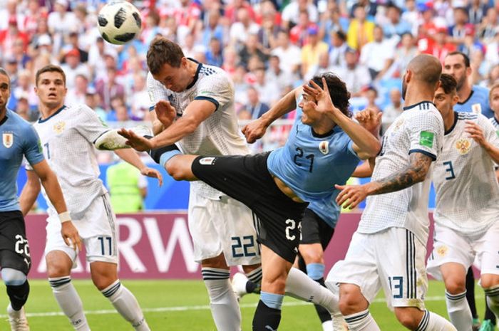 Aksi striker timnas Uruguay, Edinson Cavani (tengah, 21), saat berduel dengan penyerang Rusia, Artem Dzyuba (22), dalam pertandingan Grup A Piala Dunia 2018 di Stadion Samara Arena, Samara, Rusia, pada Senin (25/6/2018).