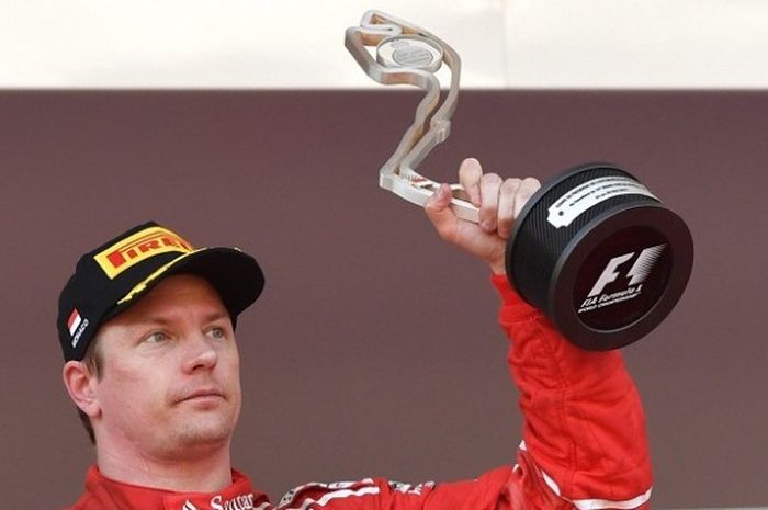 Pebalap Scuderia Ferrari, Kimi Raikkonen, mengangkat paial setelah finis di urutan kedua pada balapan GP Monaco di Sirkuit Monaco, Monte Carlo, Minggu (28/5/2017).