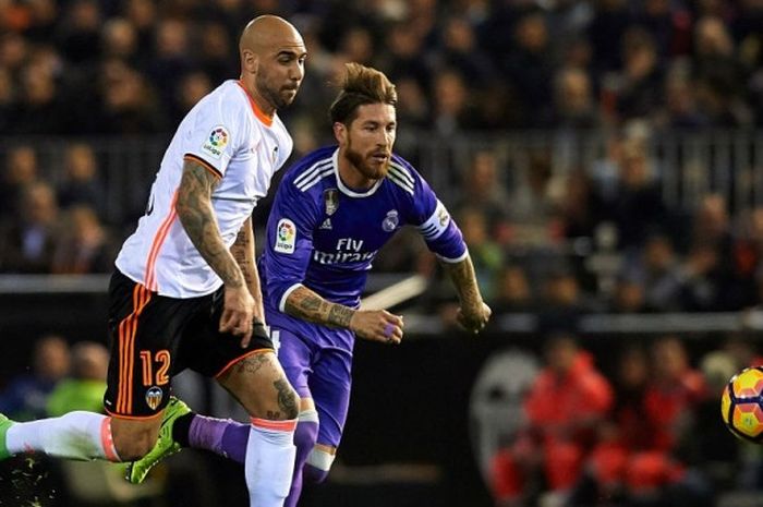 Penyerang Valencia, Simone Zaza (kiri), berduel dengan kapten Real Madrid, Sergio Ramos, dalam pertandingan La Liga di Stadion Mestalla, Valencia, Spanyol, pada 22 Februari 2017.