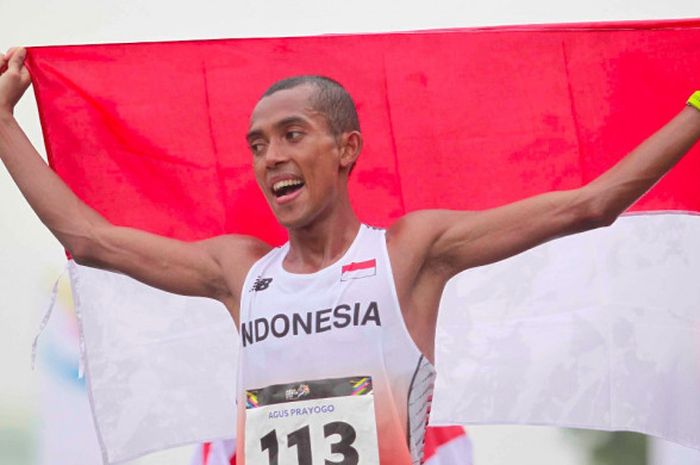 Pelari maraton Indonesia, Agus Prayogo, memegang bendera Merah Putih seusai meraih medali perak pertama untuk Indonesia pada SEA Games 2017 di National Stadium KL Sport City, Bukit Jalil, Sabtu (19/8/2017).