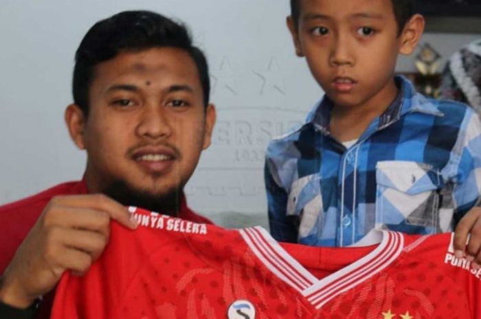 Kiper andalan Persib Bandung, Muhammad Natshir, memberikan hadiah jersey kepada seorang bobotoh cili