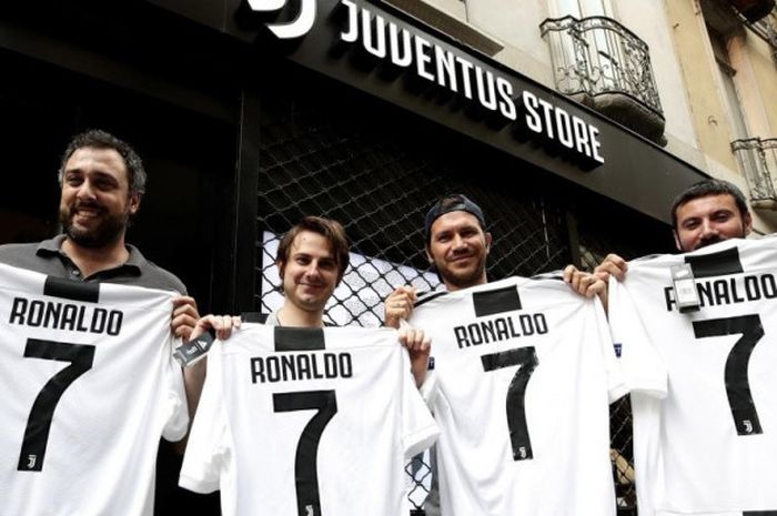   Para pendukung Juventus berpose dengan seragam nomor punggung 7 bertuliskan nama Cristiano Ronaldo di depan gerai Juventus Store di Turin, 10 Juli 2018.  