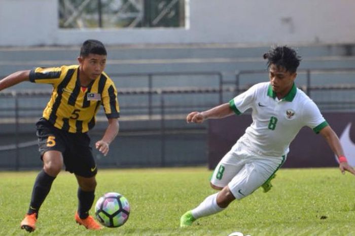  Gelandang timnas U-16 Indonesia, Andre Oktaviansyah (kanan) mencoba menghadang laju pemain timnas U-16 Malaysia pada laga uji coba di Stadion Petaling Jaya, Selangor, 6 Juli 2018.  