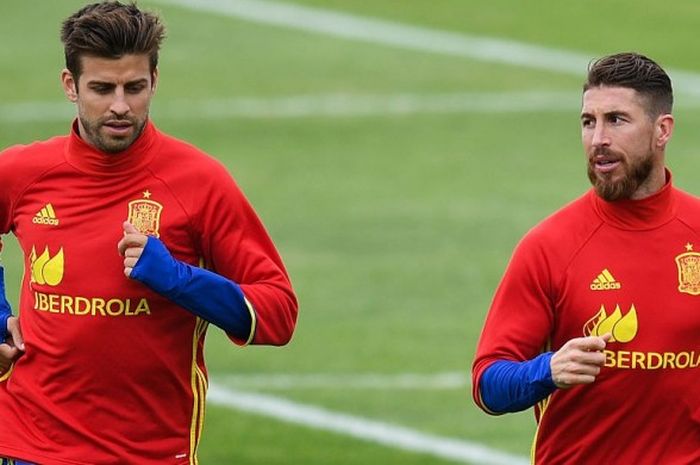 Pemain tim nasional Spanyol, Gerard Pique (kiri) dan Sergio Ramos, saat melakukan pemanasan jelang sesi latihan tim di La Rochelle, Prancis, 14 Juni 2016.