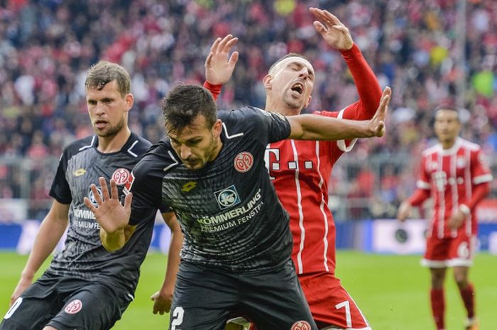 Bek Mainz, Giulio Donati (depan), berduel dengan pemain Bayern Muenchen, Franck Ribery, dalam laga Liga Jerman, 16 September 2017 di Allianz Arena, Muenchen.