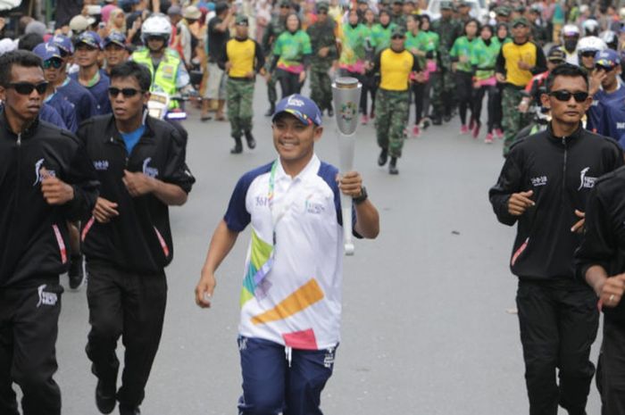 Salah satu pelari Kirab Obor Asian Games 2018 yang berlangsung di Kota Banjarmasin, Kalimantan Selatan, Senin (30/7/2018).