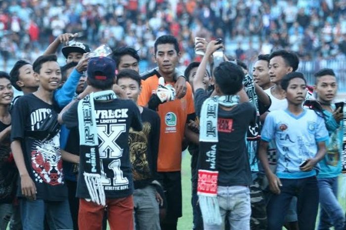 Kiper sekaligus kapten Persela, Choirul Huda dikerubungi para suporter setia timnya seusai laga kandang di Stadion Surajaya, Lamongan pada musim 2016. 