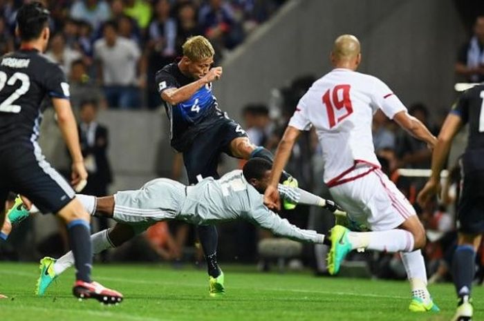  Kiper UEA, Khalid Eisa melompat untuk melakukan blok terhadap bola sepakan penyerang Jepang, Keisuke Honda di Stadion Saitama, Kamis (1/9/2016) petang waktu setempat.