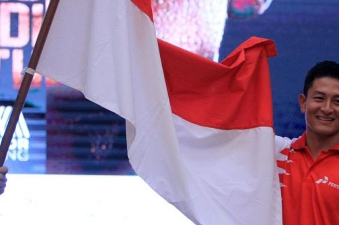 Pebalap Indonesia, Rio Haryanto, memegang bendera Merah Putih di acara pengumuman dirinya ke Formula 1, Kamis (18/2/2016).