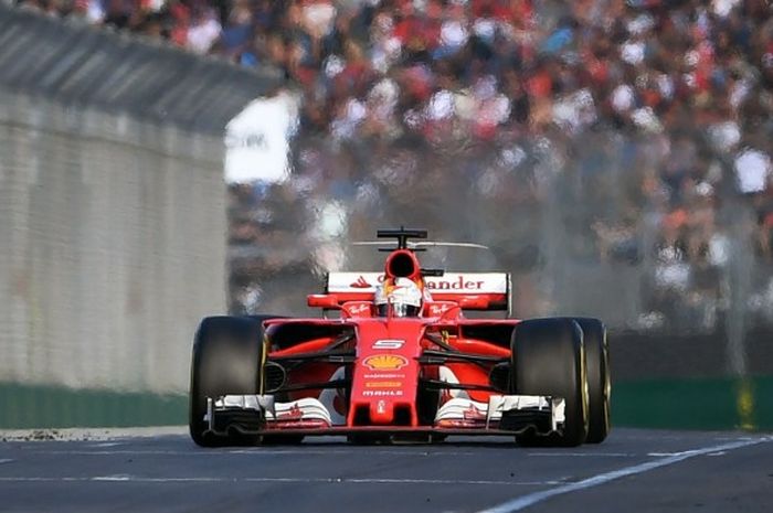 Pebalap Ferrari, Sebastian Vettel, sesaat sebelum melintasi garis finis GP Australia yang berlangsung di Sirkuit Melbourne Grand Prix, Albert Park, Minggu (26/3/2017). Vettel tampil sebagai juara dengan mengalahkan Lewis Hamilton (Mercedes).