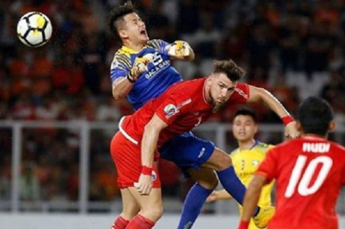 Striker Persija Jakarta Marko Simic (depan) berebut bola dengan kiper Song Lam Nghe An, Le Quang Dai dalam duel penyisihan Grup H Piala AFC 2018, Rabu (14/3/2018) malam WIB.