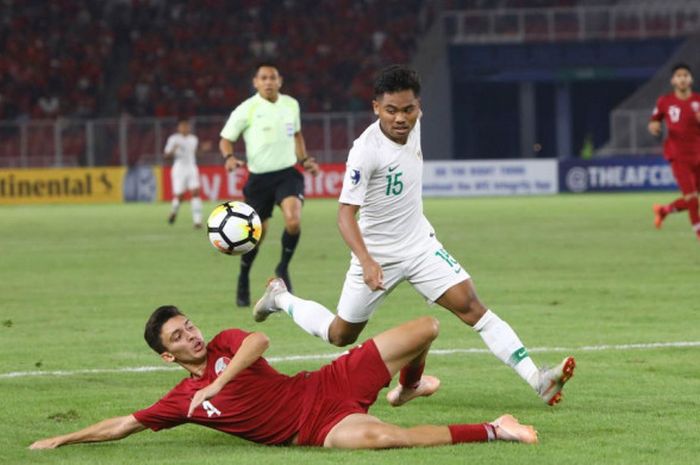 Pemain timnas U-19 Indonesia, Saddil Ramdani, berduel dengan pemain Qatar pada laga fase grup Piala Asia U-19 2018 di Stadion Utama Gelora Bung Karno, Jakarta, Minggu (21/10/2018).