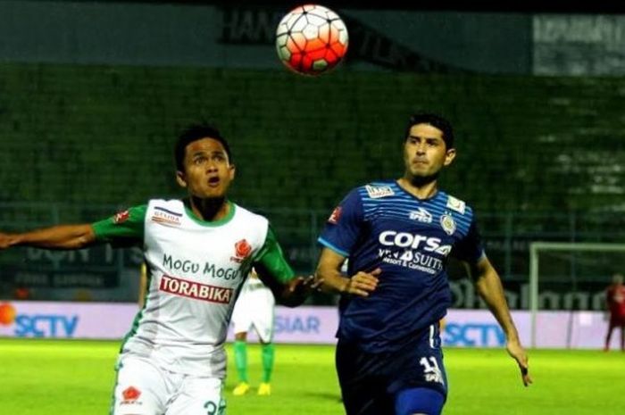 Bek PS TNI, Wiganda Pradika (kiri) adu lari untuk berebut bola dengan gelandang Arema, Esteban Vizcarr di Stadion Kanjuruhan, Kab Malang, Jumat (25/11/2016) malam. 