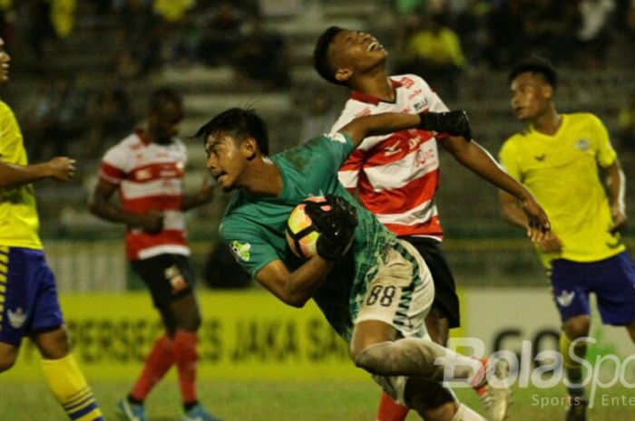 Aksi kiper Satria Tama Hardianto (Madura United) dalam pertandingan melawan Persegres Gresik United.