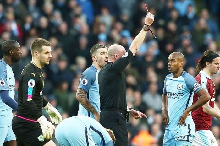 Lee Mason, wasit yang memimpin pertandingan antara Manchester City  versus Burnley, memberikan hukuman kartu merah kepada gelandang Manchester City, Fernandinho, akibat melakukan pelanggaran kepada gelandang Burnley, Johann Gudmundsson, dalam laga lanjutan Premier League 2016-2017 di Stadion Etihad, Manchester, 2 Januari 2017.