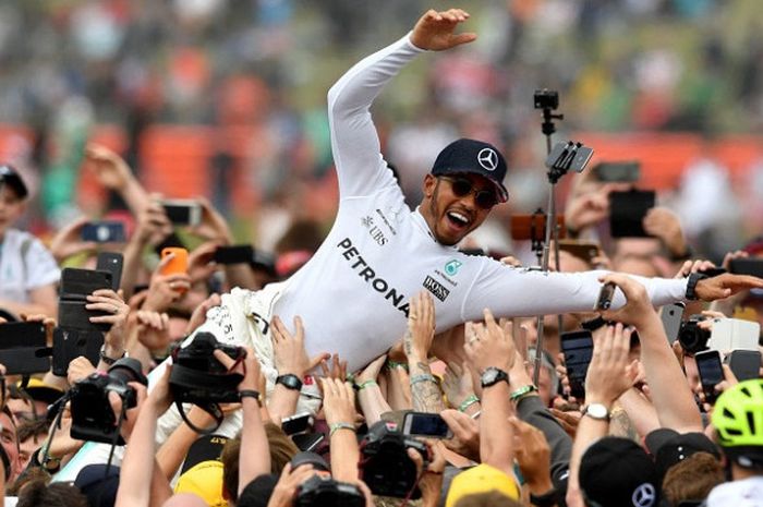  Pebalap Mercedes asal Inggris, Lewis Hamilton, diangkat-angkat oleh para penggemarnya seusai balapan GP Inggris di Sirkuit Silverstone, 16 Juli 2017. 