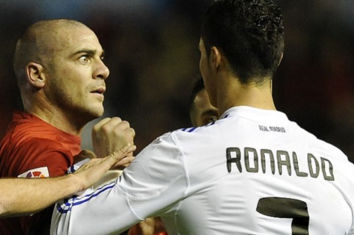 Striker Osasuna, Walter Pandiani (kiri), bersitegang dengan bintang Real Madrid, Cristiano Ronaldo, saat kedua tim bertemu di lanjutan laga Liga Spanyol pada 30 Januari 2011.