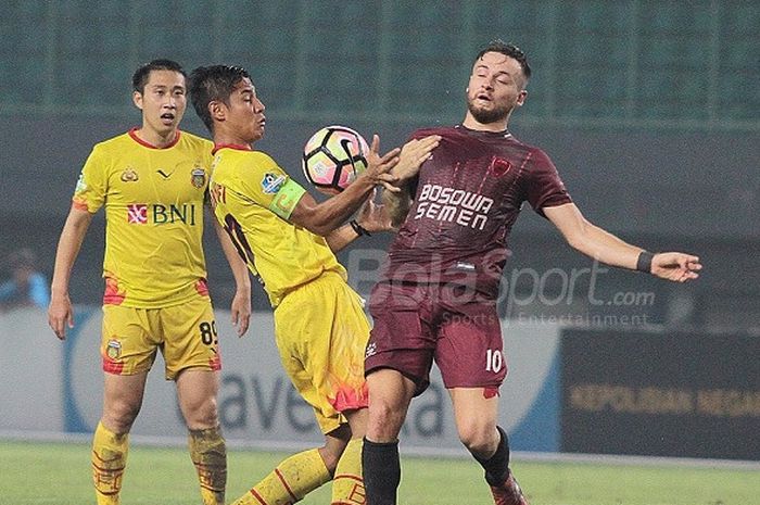    Pemain PSM Makassar Marc Klok berebut bola dengan bek Bhayangkara FC Indra Kahfi di Stadion Patriot, Kamis (19/10/2017)   