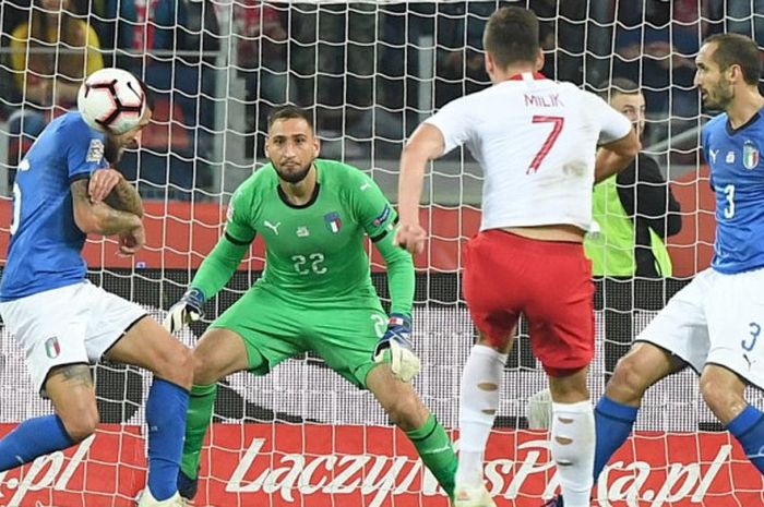 Kiper Gianluigi Donnarumma bersiap menghadapi tembakan yang dilepaskan Arkadiusz Milik dalam partai UEFA Nations League antara timnas Polandia vs Italia di Chrozow, 14 Oktober 2018.