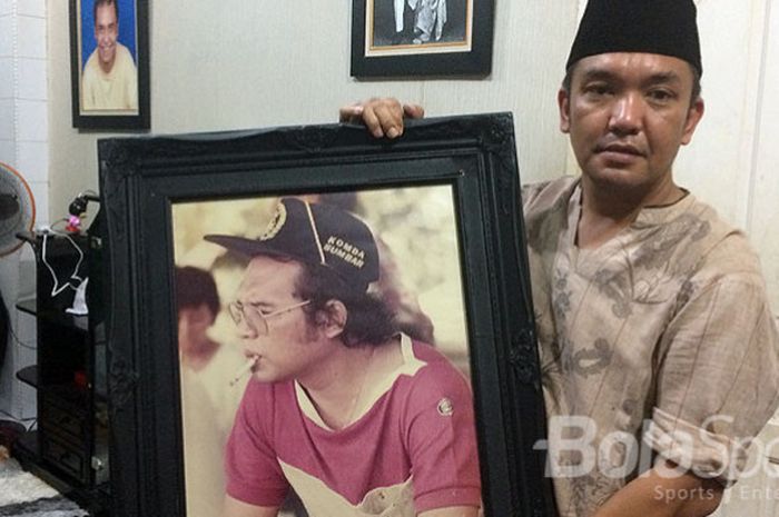 Amorta, putra kedua alm Amran YS memegang foto di rumah duka, Jalan Medan Area, Medan.