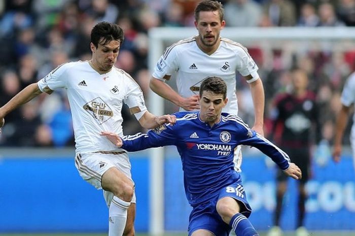 Gelandang Chelsea, Oscar (biru), mempertahankan bola dari kawalan ketat pemain Swansea City, Jack Cork, dalam duel Premier League di Stadion Liberty, 9 April 2016.