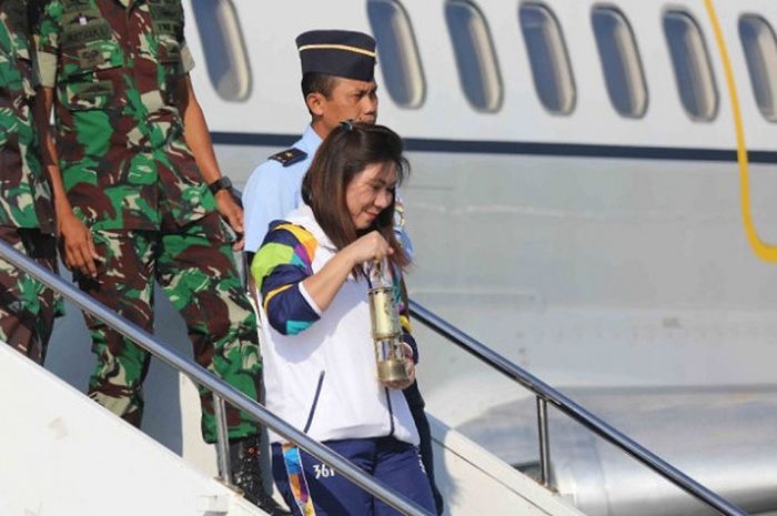 Mantan pebulu tangkis nasional Indonesia, Susy Susanti, turun dari pesawat dengan membawa api dari India untuk kirab obor Asian Games 2018 di Bandara Adi Sutjipto, Yogyakarta, Selasa (17/7/2018).