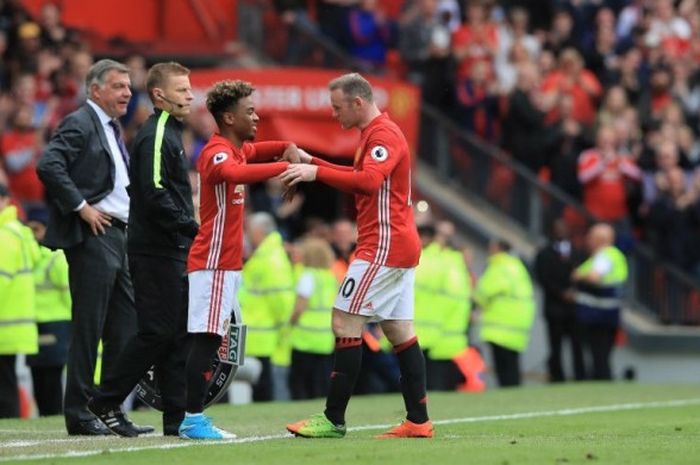 Penyerang Manchester United, Wayne Rooney (kanan), saat ditarik keluar dan digantikan Angel Gomes dalam pertandingan Liga Inggris 2016-2017 menghadapi Crystal Palace di Stadion Old Trafford, Manchester, Inggris, pada Minggu (21/5/2017).