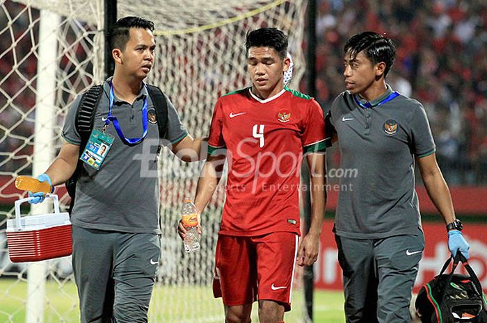 Pemain timnas U-19 Indonesia, Samuel Christianson, mendapat perawatan dari tim medis usai berbenturan dengan pemain belakang Singapura dalam laga Grup A Piala AFF U-19 2018 di Stadion Gelora Delta Sidoarjo, Jawa Timur, Selasa (03/07/2018) malam.