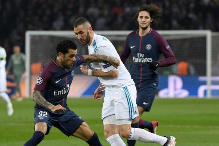 Bek kanan Paris Saint-Germain, Dani Alves (kiri), berebut bola dengan penyerang Real Madrid, Karim Benzema, dalam laga leg kedua babak 16 besar Liga Champions di Stadion Parc des Princes, Paris, Prancis, pada 6 Maret 2018.