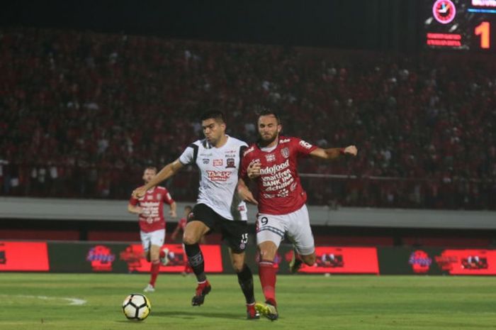 Penyerang Bali United, Ilija Spasojevic, berduel dengan bek Madura United, Fabiano Beltrame, pada laga Liga 1 2018 di Stadion Kapten I Wayan Dipta, Gianyar, Bali, Sabtu (3/11/2018).