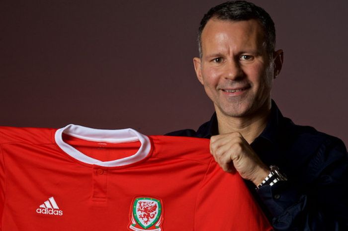 Ryan Giggs berpose bersama seragam Tim Nasional Wales sesaat setelah resmi ditunjuk sebagai pelatih baru.