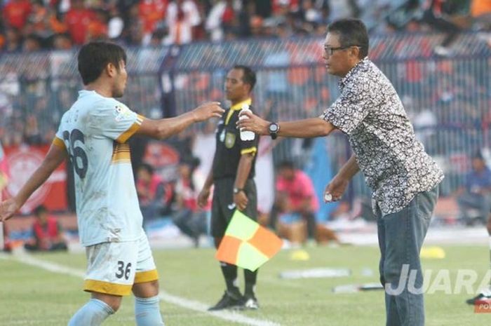 Pelatih Persela, Heri Kiswanto memberikan air mineral pada Edy Gunawan saat jeda laga kontra Persija, Rabu (10/5/2017) di stadion Surajaya Lamongan.