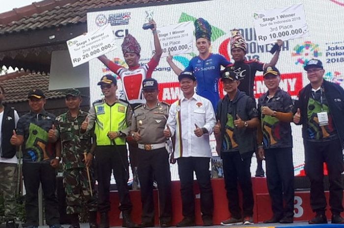 Pebalap asal Sapura, Cycling Page Dylan (tengah) berpose di podium setelah memenangi etape pertama Tour de Indonesia (TdI) 2018, Kamis (25/1/2018).