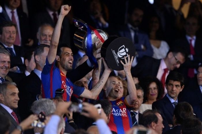 Kapten FC Barcelona, Andres Iniesta, dan rekannya, Sergio Busquets, mengangkat trofi Copa del Rey setelah mengalahkan Deportivo Alaves dalam laga final di Stadion Vicente Calderon, Madrid, Spanyol, pada 27 Mei 2017.