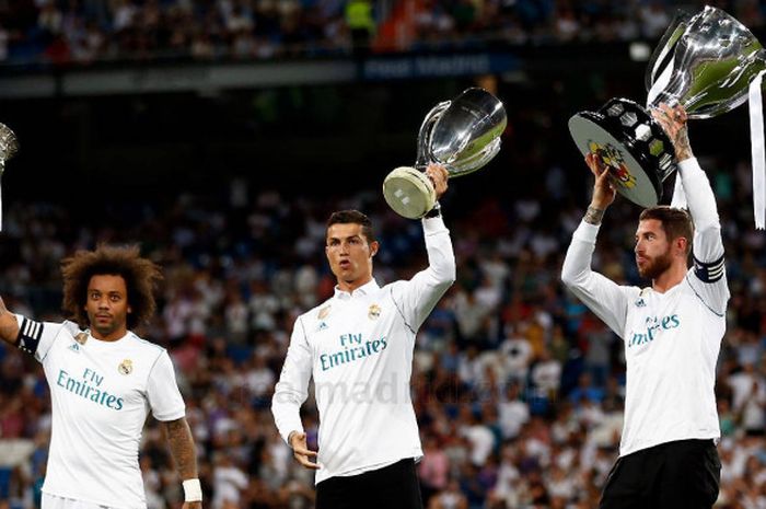 Tiga bintang Real Madrid Marcelo (kiri), Cristiani Ronaldo (tengah) dan Sergio Ramos (kanan), saat mengangkat tiga trofi yang dimenangkan Madrid pada musim 2016/2017 pada Senin (28/8/2017) di Stadion Santiago Bernabeu, Madrid, Spanyol.