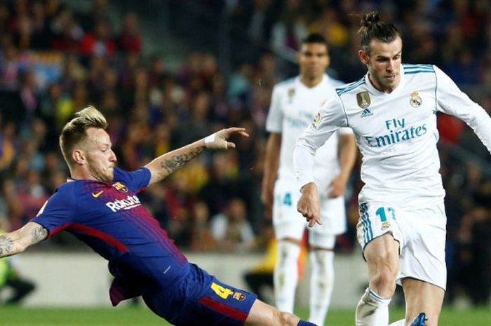   Penyerang Real Madrid, Gareth Bale (kanan), berduel dengan gelandang FC Barcelona, Ivan Rakitic, dalam laga Liga Spanyol di Stadion Camp Nou, Barcelona pada 6 Mei 2018.  