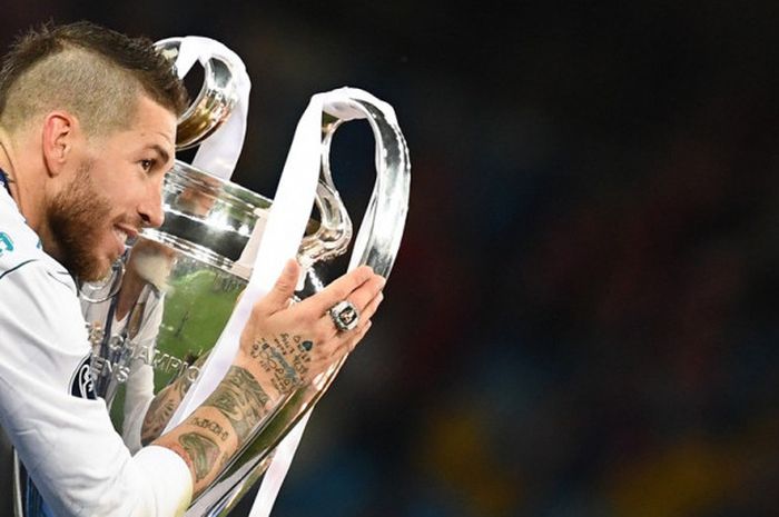 Bek Real Madrid, Sergio Ramos, melakukan selebrasi dengan memegang trofi Liga Champions seusai mengalahkan Liverpool FC dalam laga final di Stadion NSC Olimpiyskiy, Kiev, Ukraina pada 26 Mei 2018.    