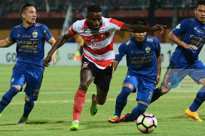 Penyerang Madura United, Greg Nwokolo dikepung tiga pemain Persib, Kim Kurniawan (kiri), Wildansyah, dan Dedi Kusnandar (kanan) pada laga pekan ke-13 Liga 1 musim 2017 di Stadion Gelora Ratu Pamelingan, Pamekasan, Minggu (9/7/2017) malam.