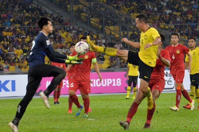 Penyerang timnas Malaysia, Norshahrul Idlan Talaha (kanan) mencoba merebut bola dari kiper timnas Laos, Vanna Bounlovongsa pada laga kedua Grup A Piala AFF 2018 di Stadion Nasional Bukit Jalil, Kuala Lumpur, 12 November 2018.  