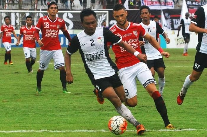 Bek PSM, Hendra Wijaya (2) mencoba melindungi bola dari kejaran striker Bali United, Nemanja Vidakovic di Stadion Kapten I Wayan Dipta, Gianyar, Selasa (6/12/2016). 