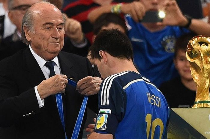 Mantan Presiden FIFA, Sepp Blatter, saat mengalungkan medali runner-up Piala Dunia 2014 kepada bintang Argentina, Lionel Messi