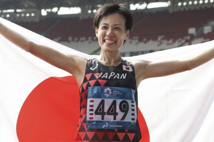 Pelari Jepang, Keiko Nogami, membawa bendera negaranya usai finis pada nomor maraton putri Asian Games ke-18 di Stadion Usama Gelora Bung Karno, Jakarta, Minggu (26/8/2018). 