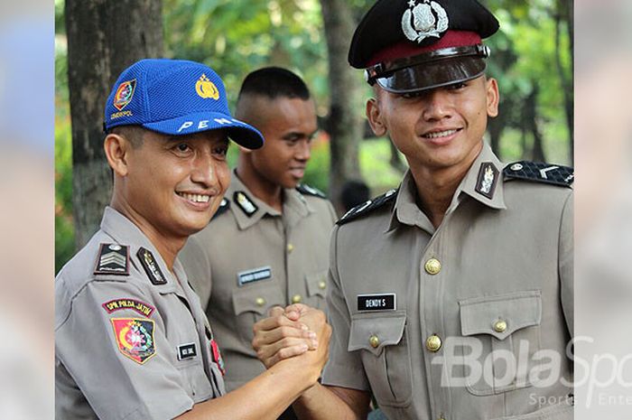 Penyerang Bhayangkara FC, Dendi Sulistyawan (kiri) seusai pelantikan menjadi anggota polisi di SPN Bangsal, Mojokerto.