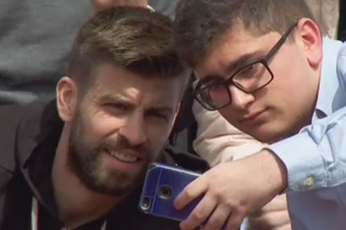 Gerard Pique menerima ajakan foto seorang penggemar ketika menonton pertandingan tenis di Valencia