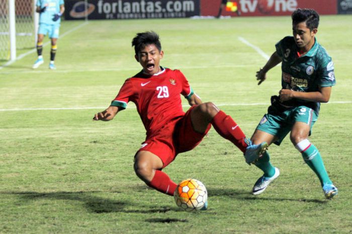 Pemain timnas Indonesia U-19 Firza Andika menghadang pemain PSS Sleman Bagus Nirwanto, Sabtu (12/8/2017)