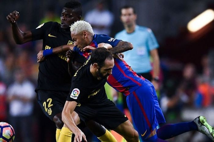Penyerang Barcelona, Neymar Jr. (tengah), berupaya menjangkau bola di tengah duel dengan pemain Atletico Madrid, Juanfran (depan) dan Thomas Partey, dalam partai La Liga di Stadion Camp Nou, Barcelona, 21 September 2016.