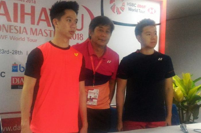 Pasangan ganda putra bulu tangkis Indonesia, Marcus Gideon (kanan) dan Kevin Sanjaya Sukamuljo (kiri) berforo bersama pelatih Herry Iman Pierngadi dalam jumpa pers seusai laga perempat final Indonesia Masters 2018 di Istora Senayan, Jakarta Selatan, pada Jumat (26/1/2018).