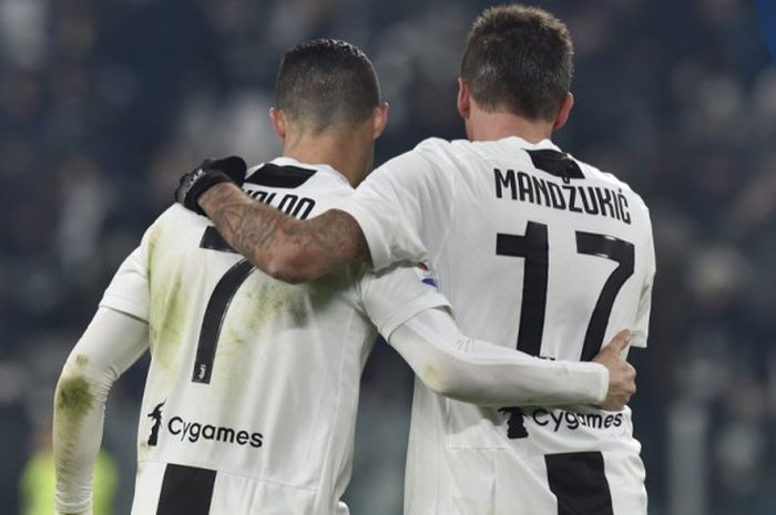 Dua pemain Juventus, Cristiano Ronaldo dan Mario Mandzukic, saling merangkul dalam laga Liga Italia melawan AS Roma di Stadion Allianz, Turin pada 22 Desember 2018.