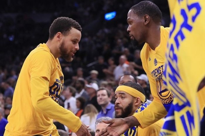 Guard Golden State Warriors, Stephen Curry (kiri), melakukan tos dengan rekan setim, Kevin Durant, pada paruh kedua laga gim keempat final NBA Wilayah Barat melawan San Antonio Spurs di AT&T Center, San Antonio, Texas, Senin (22/5/2017).