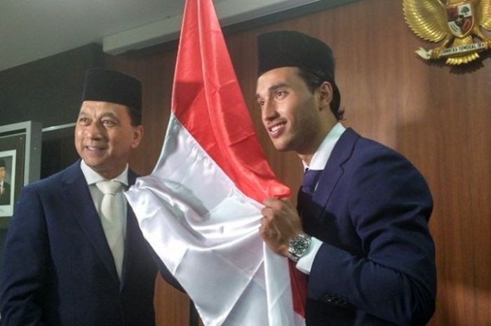 Striker timnas Indonesia, Ezra Walian (kanan) dan ayahnya Gleen Walian (kiri), memegang bendera merah putih selepas disumpah menjadi WNI di Kanwil Kemkumham, Cawang, Jakarta Timur, Kamis (18/5/2017).